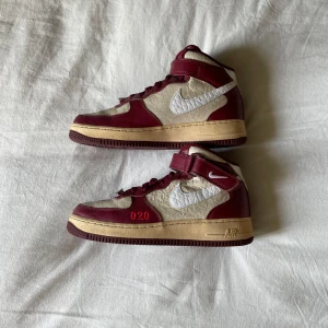 Nike Air Force 1 High röd och beige - Säljer ett par Nike Air Force 1 High med röd och beige färgkombination. Skorna har vit swoosh, röd broderad 020-detalj och beige sula. Hög modell med snörning och kardborreband upptill. Perfekta för dig som gillar unika sneakers. Hör gärna av dig vid frågor!😃