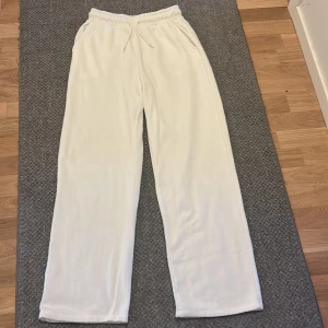 Vita mjukisbyxor från 157, stl S - Vita mjukisbyxor från 157 med rak passform och resår i midjan samt snörning. Byxorna är tillverkade i mjukt material och har en clean look utan synliga loggor eller detaljer. Perfekta för chill dagar eller när du vill ha det bekvämt.