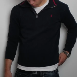 Mörkblå stickad tröja från Ralph Lauren - Säljer en mörkblå stickad tröja från Ralph Lauren med halv dragkedja och röd logga på bröstet. Pris kan diskuteras 🙂👌