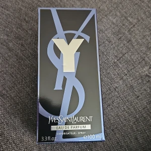 Yves Saint Laurent Y Eau de Parfum 100ml - Y Eau de Parfum från Yves Saint Laurent i en stilren, svart och transparent glasflaska med metallisk etikett och mörkgrått lock. Doften kommer i en snygg svart och blå kartong. Flaskan rymmer 100 ml och har en modern, maskulin design.