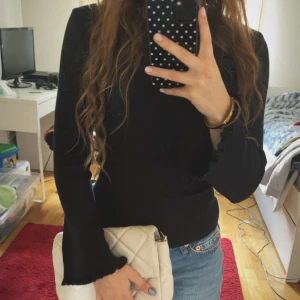 Svart tröja - Säljer en varm svart  tröja med utsvängda ärmar ärmar och fina volangdetaljer. Står intw storlek men passar mig som är XS 🌸Skriv om ni har frågor! 