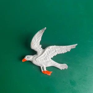 Vintage Söt Plast Fiskmås Brosch - Söt vintage brosch i plast, formad som en fiskmås med röd näbb och fötter. Silverfärgad nål på baksidan. I fint skick.