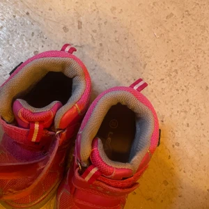 Rosa sneakers från Leaf med kardborre - Snygga rosa sneakers från Leaf med grå detaljer och vita partier. Skorna har praktisk kardborrestängning och dragflikar med randigt mönster. Ovandelen är i syntet och mesh för bra andningsförmåga. Perfekta för en aktiv vardag.