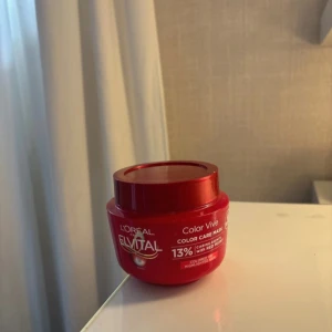 L'Oréal Elvital Color Vive hårinpackning - L'Oréal Elvital Color Vive Color Care Mask i röd plastburk. Inpackningen är ljusorange och passar färgat hår. Ger glans och vård med 13% caring agents. Perfekt för dig som vill boosta färgen och få mjukt hår. ( du ser på bild hur mycket som är kvar)
