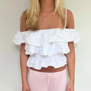 Vit volangig offshoulder topp men band - Superfin vit offshoulder topp med flera volanger och smala axelband i en croppad modell 