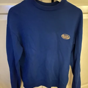 Blå sweatshirt från Multiverse - Blå sweatshirt från Multiverse med rund halsringning och tryckt logga på bröstet. Väldigt snygg💙💙