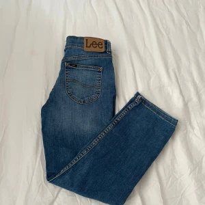 Blå Lee jeans straight fit 10-11 år - Klassiska blå jeans från Lee i straight fit-modell. Jeansen har fem fickor, normalhög midja och Lee-logga på bakfickan. Tillverkade i slitstarkt denimtyg som passar perfekt till vardags. Snygg tvätt och tidlös look priset kan diskuteras.