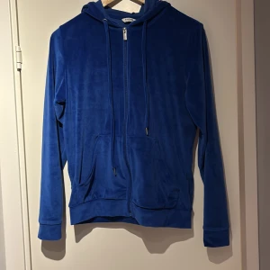 Blå velour hoodie med dragkedja - Blå hoodie från b.young i mjuk velour med huva och snörning.