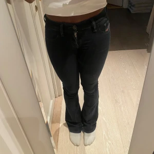 Svarta bootcut jeans från Diesel - Snygga svarta jeans från Diesel med bootcut och låg midja 