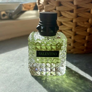 Valentino parfym - Snygg parfym från Valentino i en genomskinlig glasflaska med nitar och rutmönster. Flaskan har en ljusgrön vätska och svart kork med coola detaljer. Perfekt för dig som gillar lyxiga och trendiga dofter. Helt ny!
