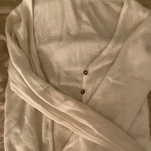 Vit ribbad kofta från FB Sister - Säljer en vit kofta från FB Sister i storlek XS. Koftan har ribbad struktur, v-ringning och två snygga knappar framtill. Pris kan alltid diskuteras vid snabb affär!💕