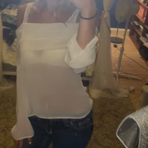Vit offshoulder blus från H&M  - Säljer en superfin vit blus från H&M Divided i storlek XS. Den är offshoulder med långa, vida ärmar och är gjord i ett tunt, transparent tyg som ger en luftig känsla. Använd en gång.