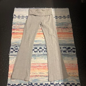 Grå bootcut byxor från Gina Tricot XS - Snygga grå bootcut byxor från Gina Tricot i mjukt och stretchigt material. De har hög midja med bred linning och utsvängda ben, perfekta för en chill och trendig look.