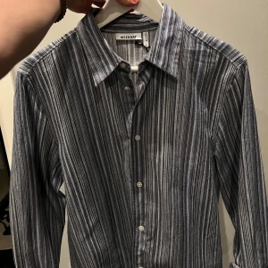 Randig skjorta från Weekday, blå/vit - Snygg randig skjorta från Weekday i blått och vitt. Storlek small, passar small. Tyngre mer oldskool material och look. Bra skick! Köpt för 479 kr
