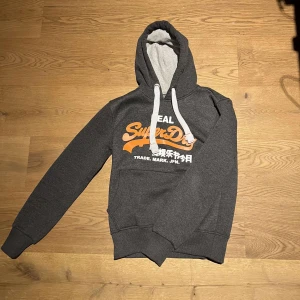 Grå Superdry hoodie  - Tja säljer min gråa super dry hoodie den är i ny skick och är i storleken xs. Skriv vid minsta fundering.
