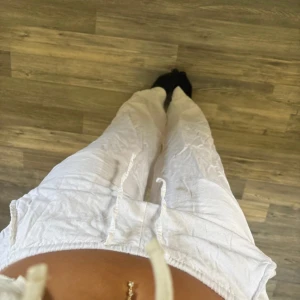 Vita linnebyxor med snörning XXS - Säljer ett par vita linnebyxor från 157 i storlek XXS. Byxorna har resår i midjan och snörning för extra komfort. De är raka i modellen och har en avslappnad passform, perfekta för varma dagar. ‼️(Obs. Hål på insidan av byxorna långt ner på benet, går att laga men inget jag orkar då man ej märk de vid Användning)‼️