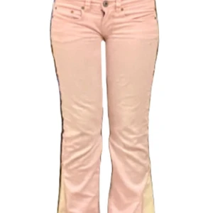 Lowwaist bootcut jeans i rosa från kappAhl  - Snygga lågmidjade bootcut byxor i ljusrosa tyg med beiga kanter längst ner som jag har sytt till och jag har även sytt de mer lowwaist. Midjemåttet platt är 37 cm och innerbenslängden är 71 cm 💕PRIS ÄR DISKUTERBART!!!