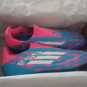Adidas F50 blå/rosa fotbollsskor - Säljer ett par Adidas F50 fotbollsskor. Använda bara under 1 träning. Märkte att dom inte var min storlek lite försent. Pris kan diskuteras