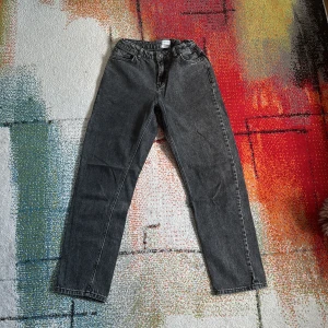 Svarta raka jeans i vintage-stil - Snygga svarta jeans med rak passform och klassisk femficksdesign. Jeansen har en något tvättad look och stängs med knapp och dragkedja. Perfekta till sneakers eller boots för en avslappnad vibe.