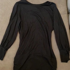 Svart tröja med paljetter - Svart tröja med långa ärmar och en snygg öppen rygg. Baksidan har en bred panel med silvriga paljetter. Passar i storlek S/M Made in greece 💓