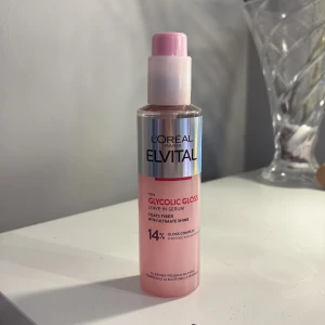 L'Oréal Elvital Glycolic Gloss Serum - L'Oréal Elvital Glycolic Gloss Leave-In Serum i en rosa plastflaska med pump. Ger glans och mjukhet till håret med 14% gloss complex och glykolsyra. Snygg holografisk etikett och praktisk pump gör den enkel att använda. Aldrig använd eller testad.