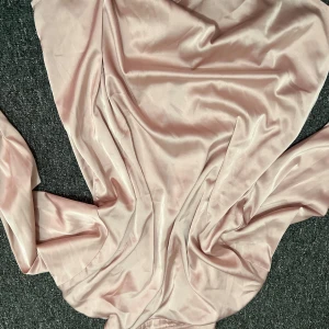 Ljusrosa satin skjorta från Cider XS - Supersöt ljusrosa skjorta från Cider i glansigt satinliknande material. Klänningen har långa ärmar, klassisk krage och knappar framtill. Perfekt för dig som gillar en chic och feminin look. Observera tre väldigt väldigt smååå fläckar som går bort med tvätt. 