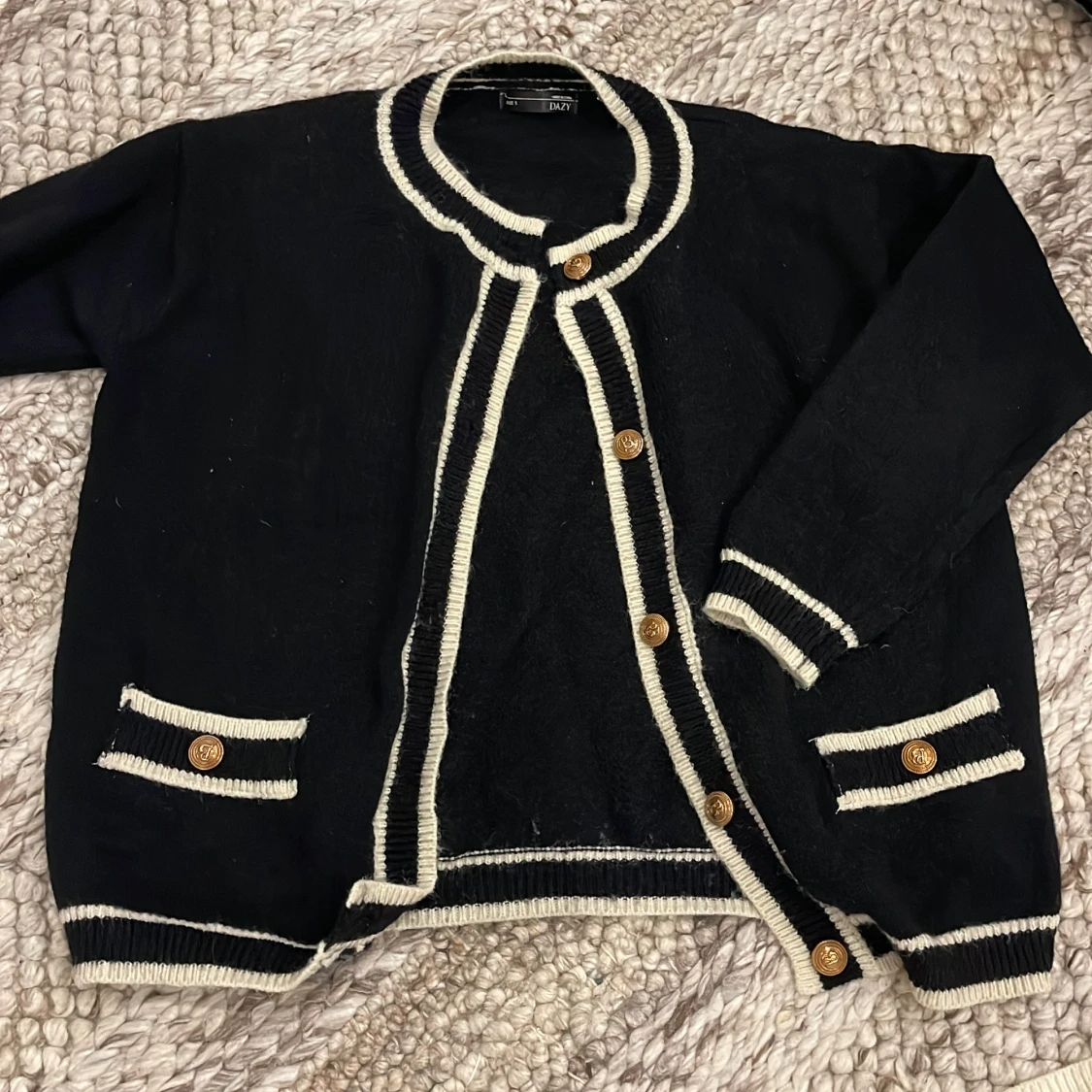 Svart kofta med vita detaljer