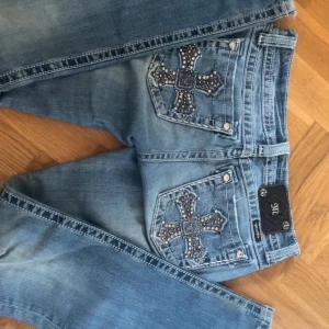 Miss Me ljusblå bootcut jeans  - Säljer ett par ljusblå lågmidjade jeans från Miss Me jeansen är i bra skick lite slitna längst ner på byxbenen men inget man ser när man har på sej de. Jeansen är i storlek 27 och längden är perfekt för mej som är 164💗