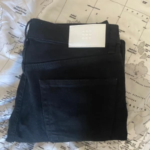 Svarta jeans  - Svarta jeans från Taktil, modell William Tapered. Snyggt minimalistiskt vitt läderpatch bak i midjan och klassiska bakfickor. Tapered fit som smalnar av nedtill, tillverkade i robust bomullstyg. Perfekta för en clean och stilren look.