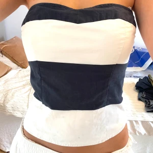 Randig tubtopp från Abercrombie & Fitch - Snygg tubtopp från Abercrombie & Fitch i marinblått och vitt med breda horisontella ränder. Toppen är bandeau-modell, har smockad baksida för extra komfort och sitter tight! Passar Xs-S skulle jag säga 
