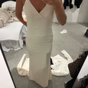 Bal/sommarklänning - Lång vit/beige färgad satin klänning, passar både för bal och sommarkvällar. Använd 1 gång. Jag är 178 cm men skulle säga att den passar för kortare bättre. Passar både S och M. ordinarie pris 899