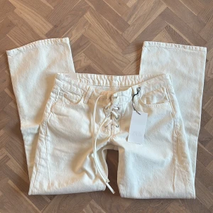 Vita bootcut jeans med snörnig - Jättesnygga vita boutcut jeans med snörning!!
