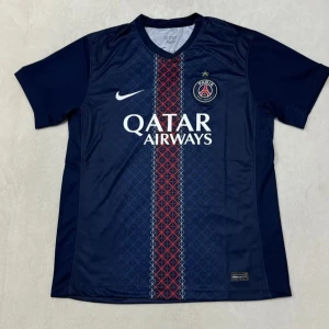 PSG matchtröja Nike blå röd 2025/26 - Finns i alla storlekar! Paris Saint-Germain fotbollströja från Nike i mörkblått med röd och vit rand längs mitten. Tröjan har korta ärmar, PSG-logga på bröstet och Qatar Airways-tryck. Pris kan diskuteras!