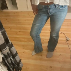 Ljusblå bootcut jeans - Säljer ett par ljusblå jeans med bootcut passform. Jeansen har klassisk femficksdesign med knappar bak, lowwaist midja och är tillverkade i mjukt denimtyg. Perfekta för dig som gillar en avslappnad och trendig look. I strl 164 men passar större strl också