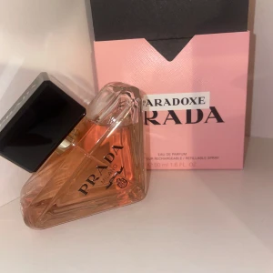Prada Paradoxe Eau de Parfum 50ml - Prada Paradoxe Eau de Parfum i en unik trekantig glasflaska med svart lock och rosa doftvätska. Kommer med en snygg rosa och svart förpackning. En lyxig och modern parfym som sticker ut i badrumshyllan.