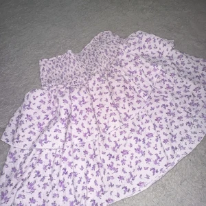 Ljuslila blommig volangkjol - Supersöt kort kjol med volanger och blommigt mönster. Passar perfekt både för xs/s/m då den är stretchig i midjan. Väldigt fin och passar till de mesta. 