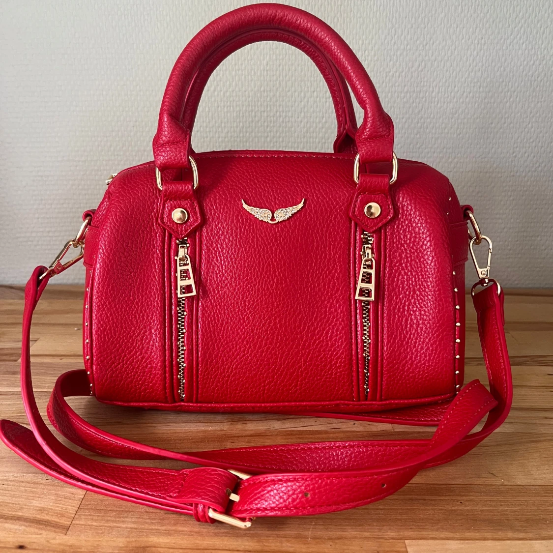 Röd handväska med gulddetaljer