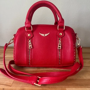 Röd handväska med gulddetaljer - Fin röd handväska! Är inte äkta men i mycket fint skick! Pris kan diskuteras💕