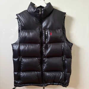 Svart dunväst från Polo Ralph Lauren - Tjena, säljer nu min Polo Ralph Lauren puffer väst använd fåtal gånger och använd försiktigt. Den har inga skador eller defekter osv.