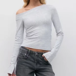 Ljusgrå offshoulder långärmad topp - Helt ny!! Slutsåld! Säljer en ljusgrå långärmad topp med offshoulder-skärning. Toppen har en tight passform och är tillverkad i mjuk bomullsmix. Perfekt för dig som gillar minimalistisk stil med en twist. Ärmarna är långa och något utsvängda vid handleden.