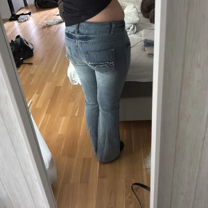 Bootcut jeans i ljusblå denim - Säljer ett par snygga bootcut jeans i ljusblå denim med slitningar på bakfickorna. Klassiska med låg midja och lätt utsvängda ben. Perfekta för dig som vill ha ett par jeans som sticker ut lite extra. Dessa jeans var från början ett par skinny jeans men valde att sy dem till bootcut och det nya tyget är på insidan så det är knappt att man märker av att de är egensyda.💕💕💕