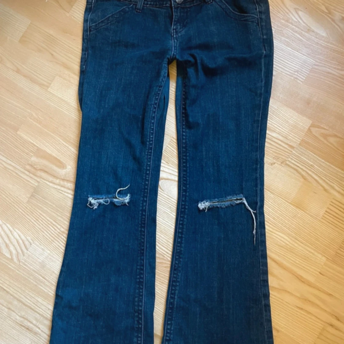 Mörkblå bootcut jeans med slitna knän