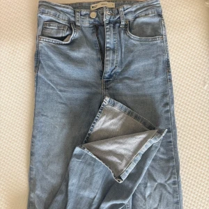 Ljusblå bootcut jeans Molly S - Ljusblå jeans från GinaTricot, modell Molly, i klassisk femficksdesign. Jeansen har hög midja och bootcut. Tillverkade i mjukt denim med dragkedja och knapp framtill. Väldigt stretchiga. Storlek S