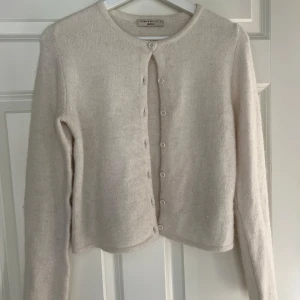 Vit stickad kofta från Gina Tricot - Mysig vit kofta från Gina Tricot. Koftan ser lite mer biege ut än vad den är i verkligheten, den är mer vit. Jättefint skick och använd endast några få gånger då jag inte tycker den sitter så fint på mig❤️