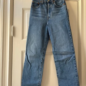 Levi's Ribcage Straight Ankle jeans - Klassiska blå Levi's Ribcage Straight Ankle jeans med hög midja och raka ben. Jeansen har fem fickor. Perfekta för en avslappnad och tidlös look.