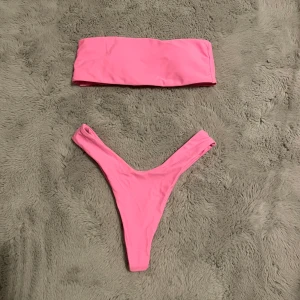 Pink highwaisted bandeau bikini - Trendig Bandeau som är högmidjat i rosa och i storlek xs 👙Bikini toppen: Byst 64cm, Underbyst 60cm, Kupa 70A och under. Bikini underdel: Midja 64-90. Det finns padding man kan ta ut om man vill också som man ser på bild 3. Aldrig använt, inga defekter, endast testad och tvättad! Säljer den för toppen är för liten för mig. ❌Visar inte bikinin på mig❌