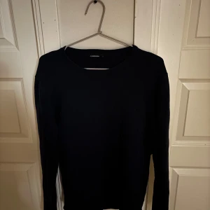 Mörkblå tröja från J.Lindeberg - Säljer en stilren mörkblå tröja från J.Lindeberg i storlek M. Tröjan har rund halsringning och långa ärmar. Perfekt för lager-på-lager och passar till många olika outfits. Bra till sommarkvällarna. Pris kan diskuteras.