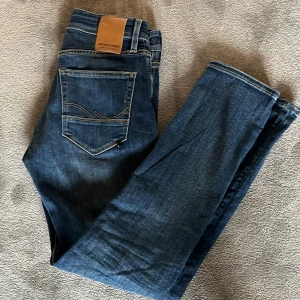 Blå slim fit jeans från Jack & Jones - Snygga blå jeans från Jack & Jones i modellen Slim/Glenn. Jeansen har klassisk femficksdesign, dragkedja och knapp i gylfen. Storlek W29 L30. Aldrig använda.