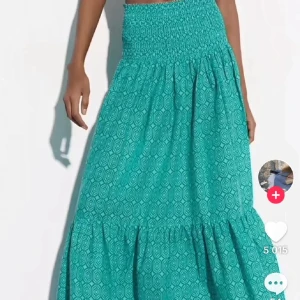 Turkos långkjol med mönster - Zara kjol säljs inte längre använt 1 gång.Säljer en turkos långkjol med smock upptill och ett diskret geometriskt mönster. Kjolen har en luftig passform och volang nertill, perfekt för varma dagar.