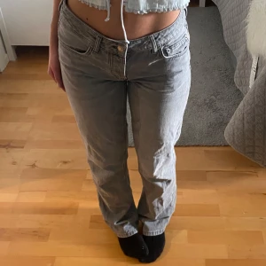 Grå raka jeans - Ett par grå jeans med rak passform. Byxorna har normal/låg midja 